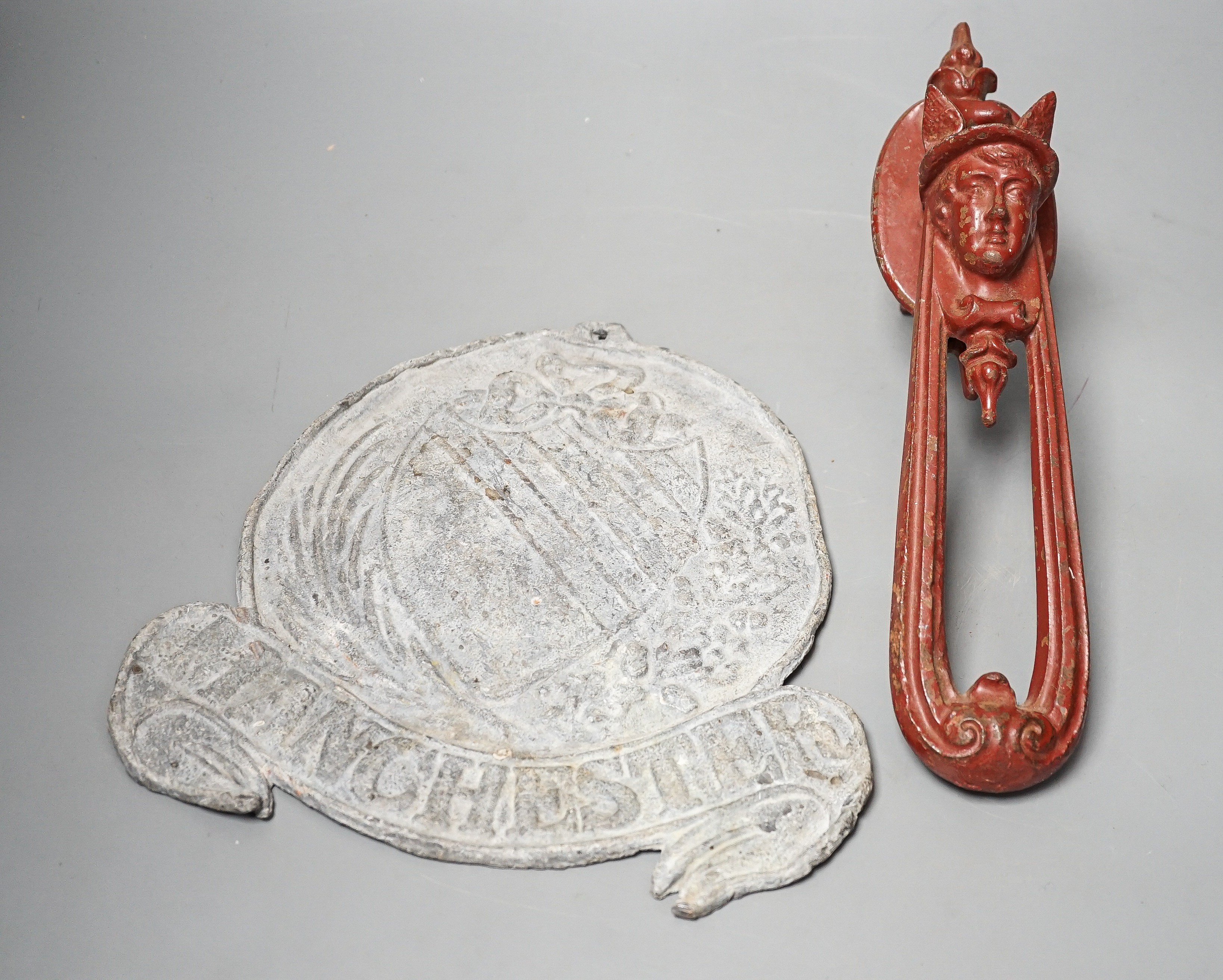 A Manchester lead plaque, 24cm high and a ‘Hermes’ cast iron door knocker